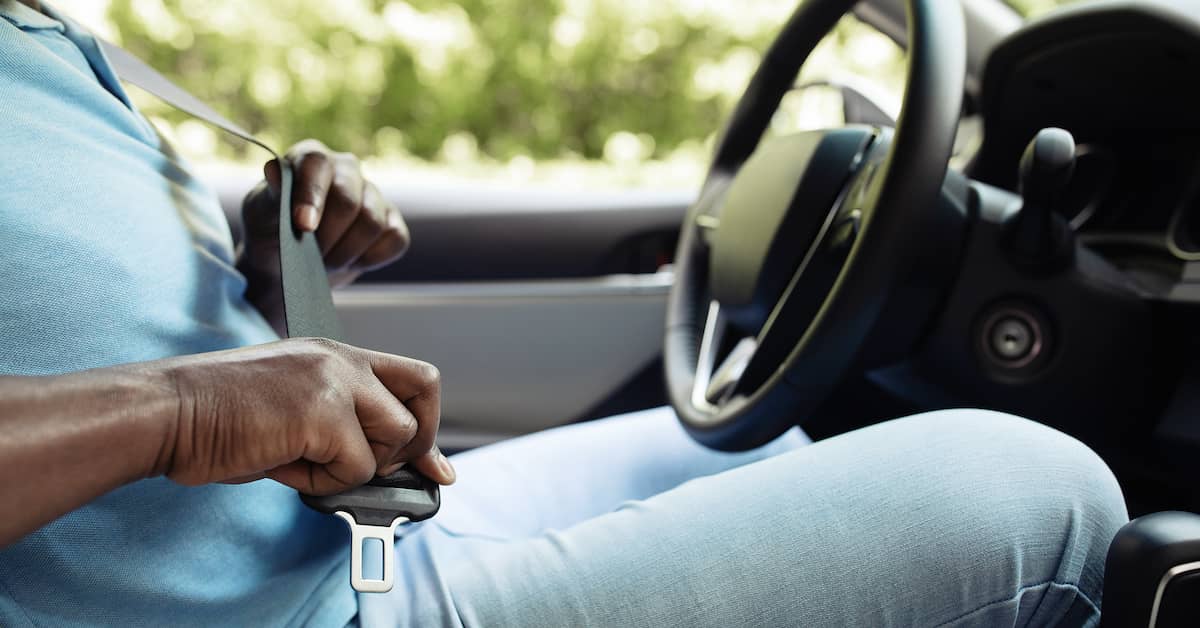 Man fastening seat belt.