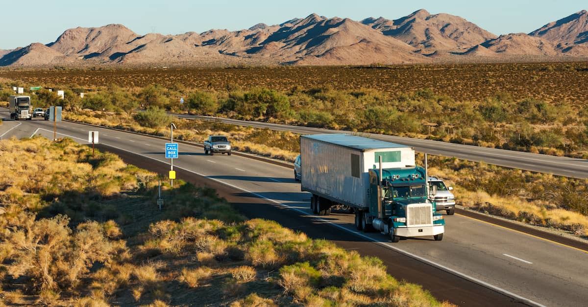 Cars on trucks sharing the road in the desert. | Patrick Daniel Law