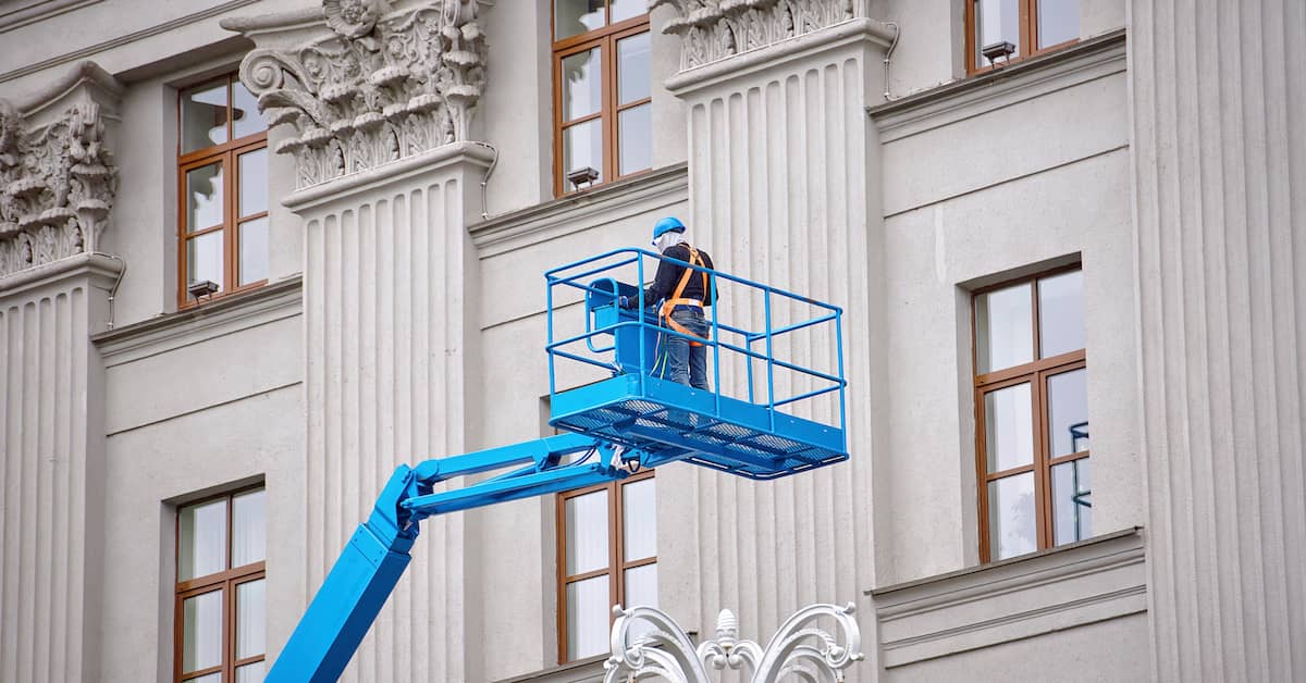 Construction worker high up on an aerial lift. | Patrick Daniel Law