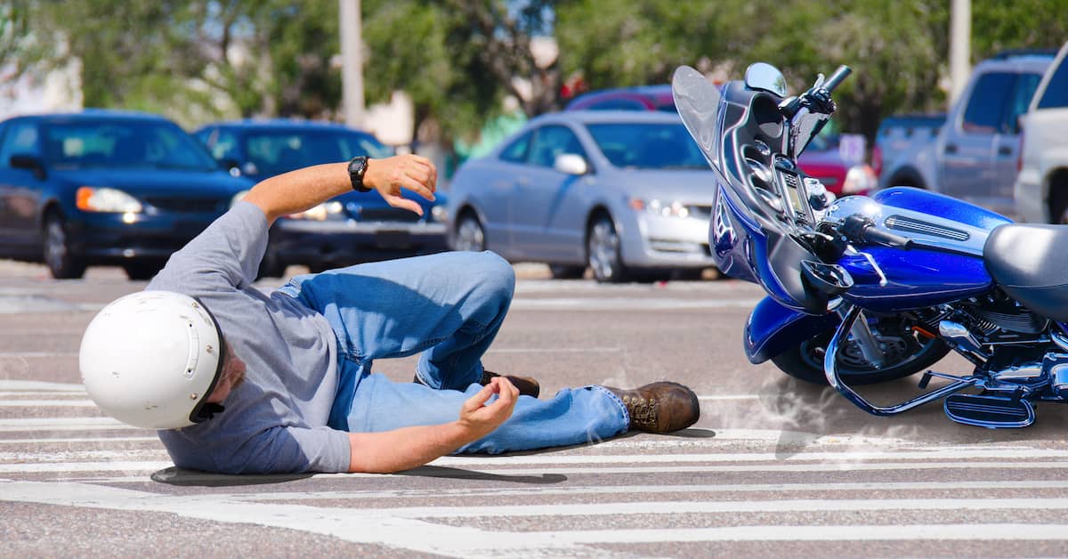 man falling on his side from a motorcycle accident