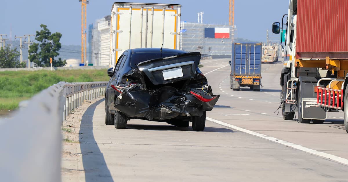 damaged car on the side of a highway after a rear-end accident in Houston, Texas