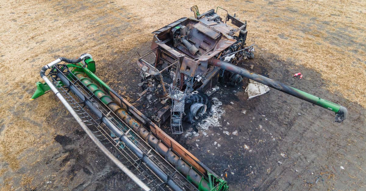 severely damaged combine harvester after a fire on the farm