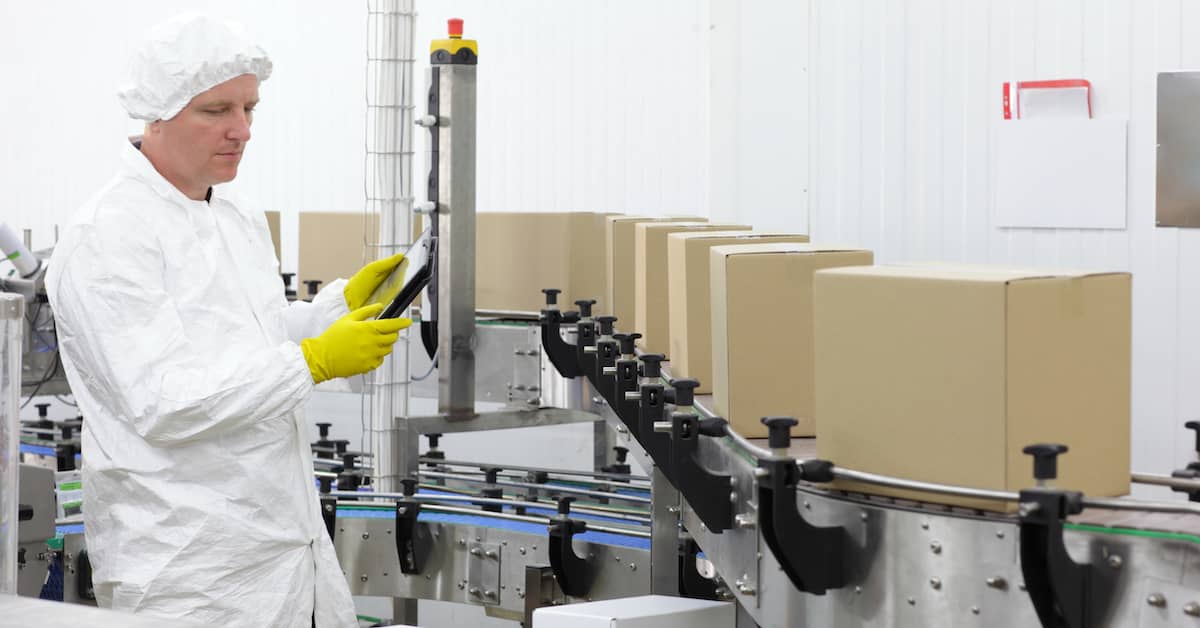 worker performing quality control on products in a factory assembly line