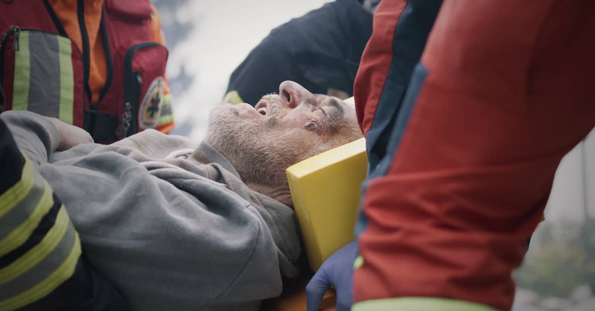 Man on stretcher with neck brace. | Patrick Daniel Law