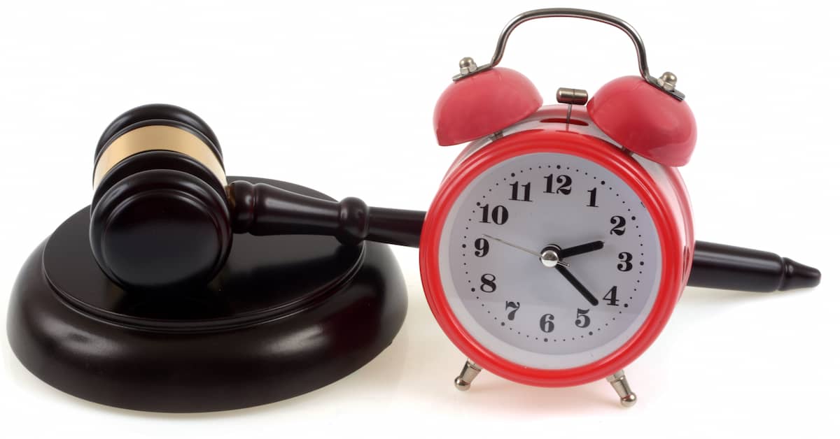 An alarm clock next to a gavel. | Patrick Daniel Law