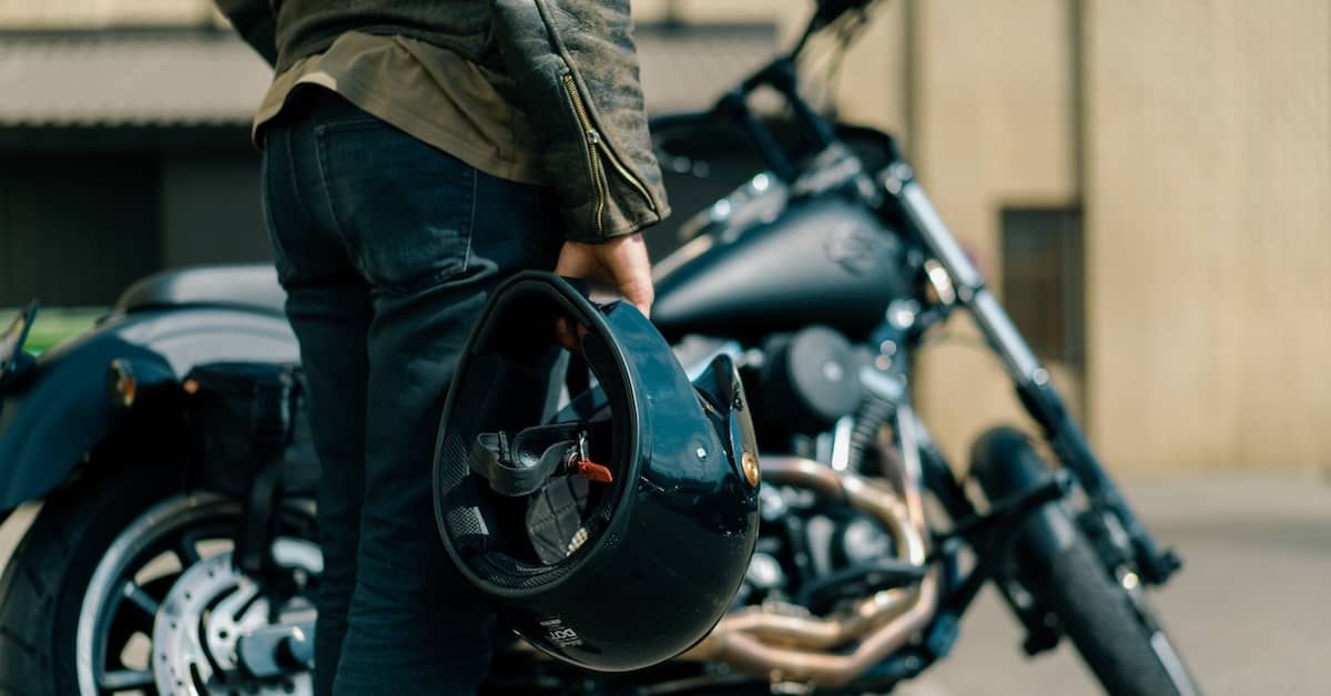 Motorcyclist holds helmet. | Patrick Daniel Law